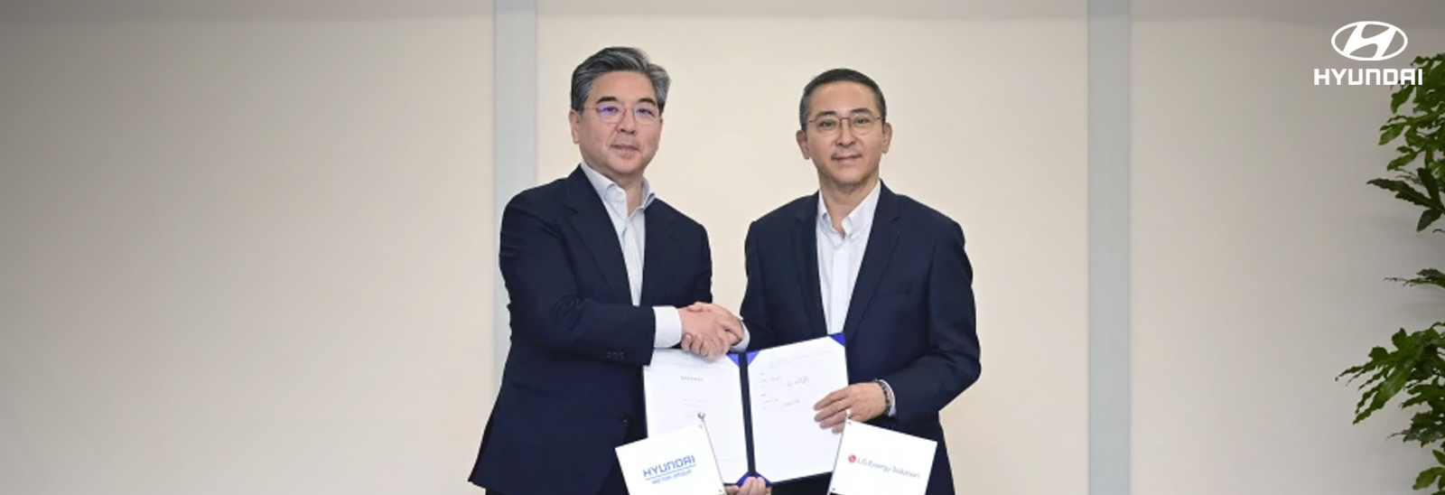Ejecutivos de Hyundai y LG estrechando manos