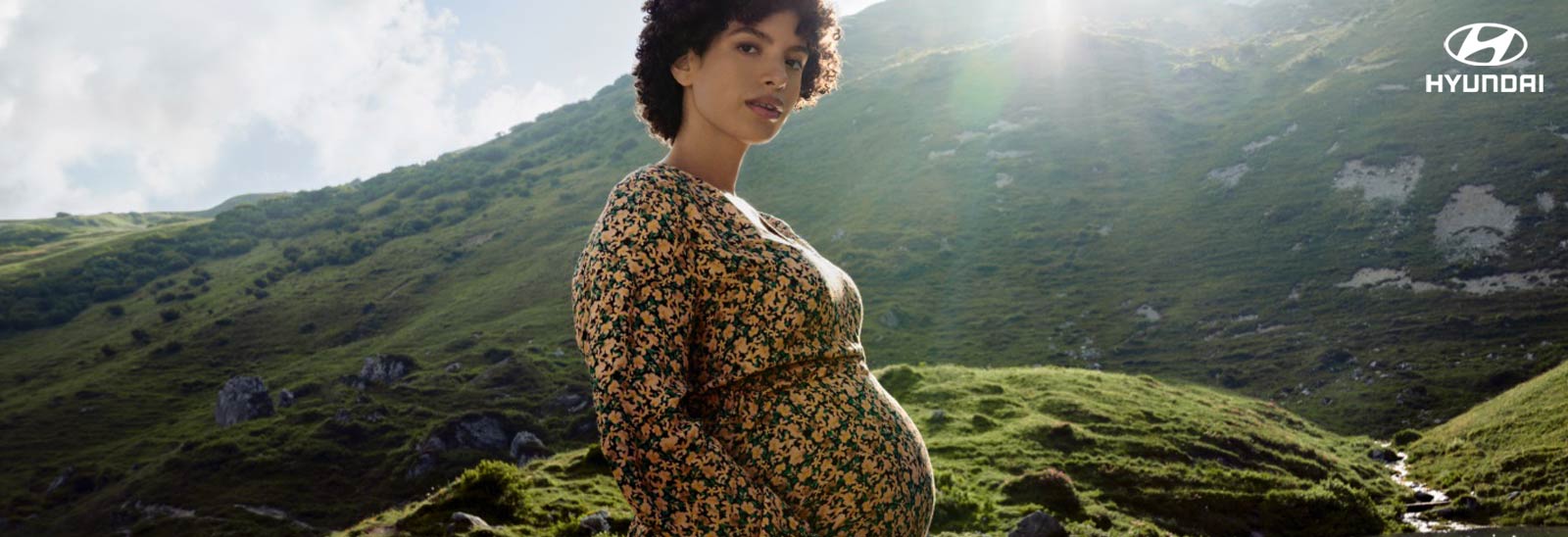 Mujer embarazada con paisaje verde de fondo