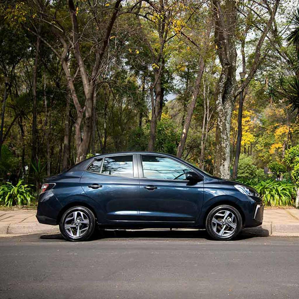 Hyundai Grand i10 Sedán  2026 color azul estacionado junto a un parque