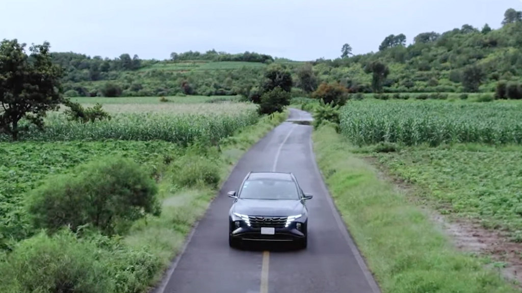 Auto de Hyundai recorriendo una carretera rodeada de cosechas