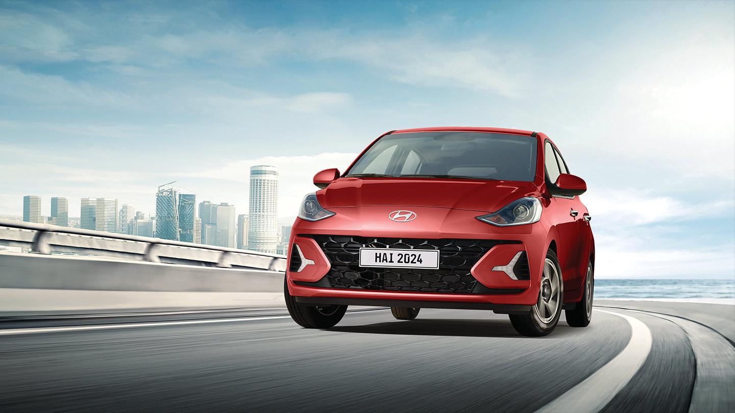 Hyundai Grand i10 Hatchback color rojo circulando por la ciudad