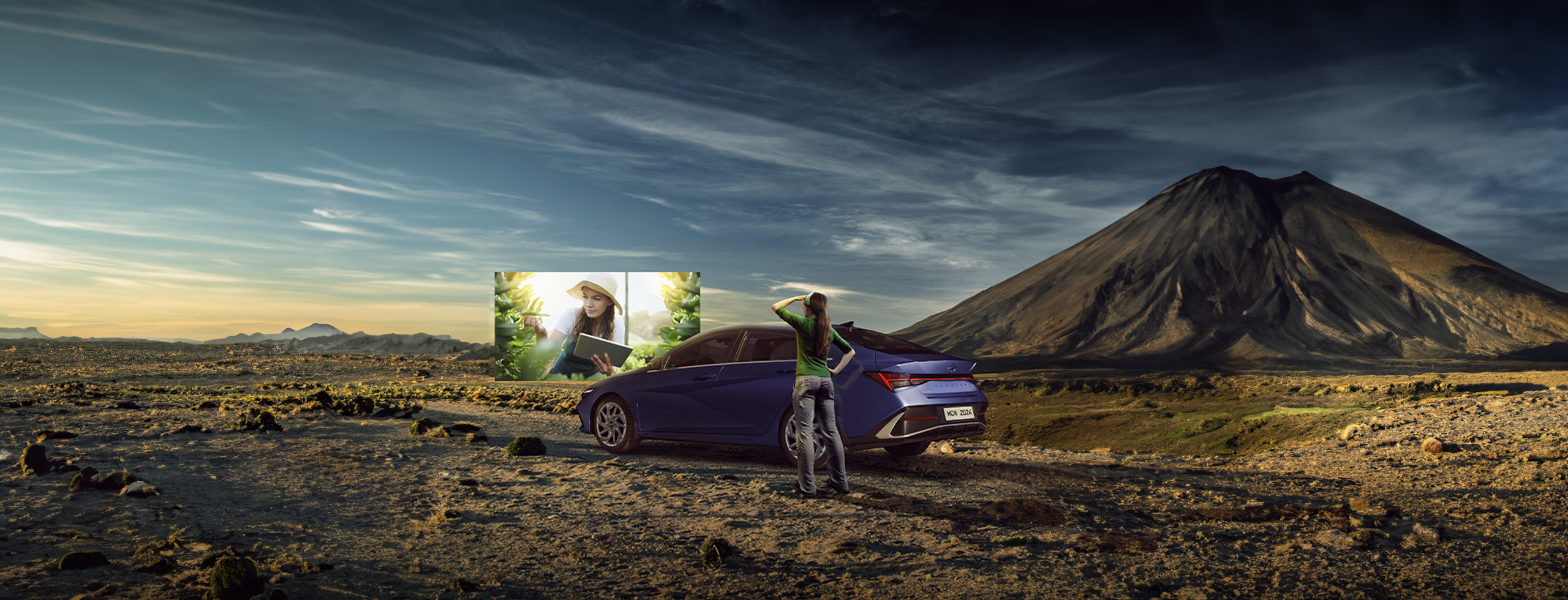 Mujer mirando al horizonte junto a Elantra híbrido azul en terreno desértico