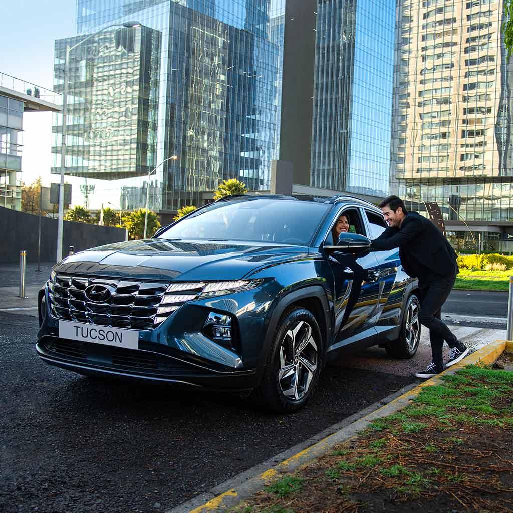 Mujer dentro de Hyundai Tucson estacionada platicando con un hombre en la calle