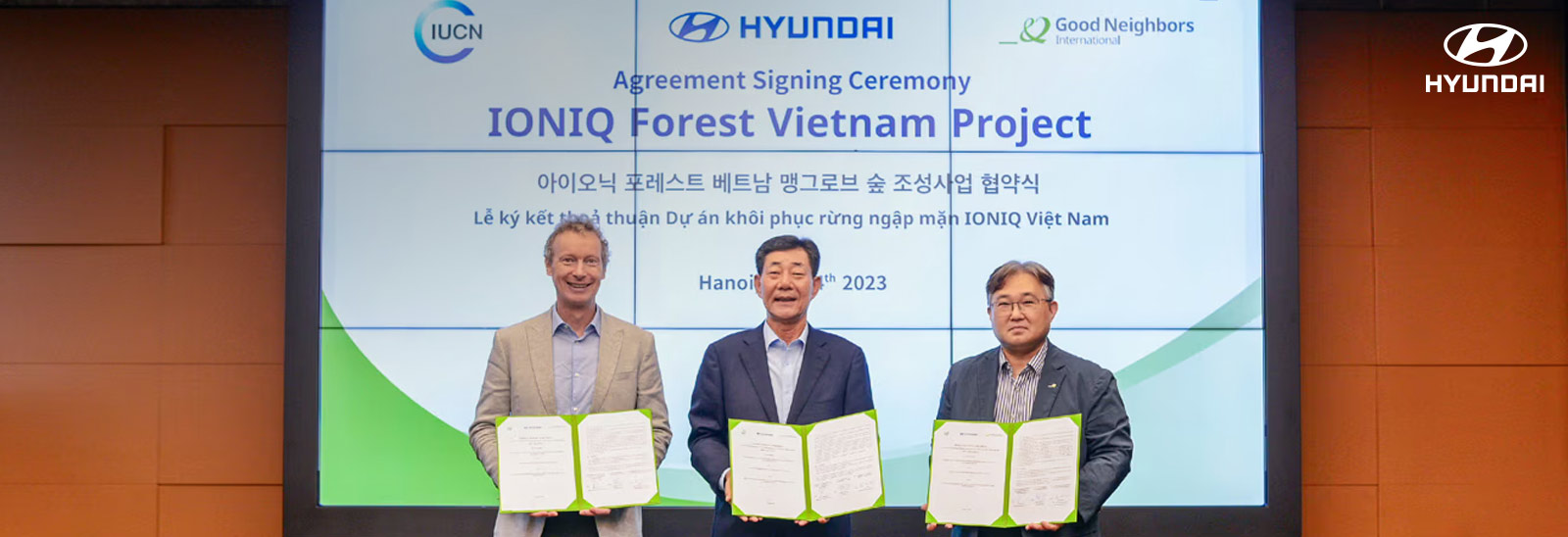 Ejecutivos de Hyundai Motor y de la Unión Internacional para la Conservación de la Naturaleza (UICN) y Good Neighbors International (GNI) mostrando carpeta con acuerdo