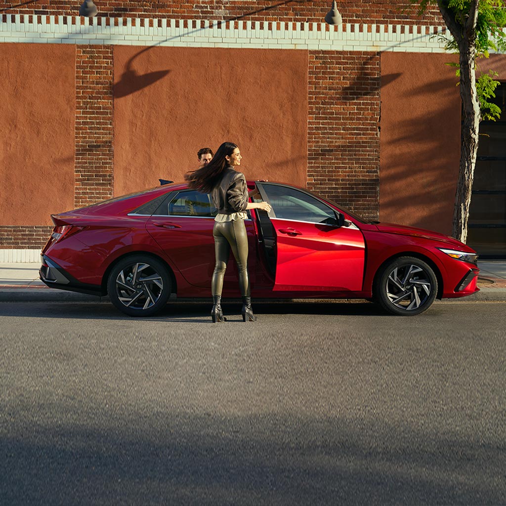 Mujer subiendo al nuevo Elantra 2024 en color rojo