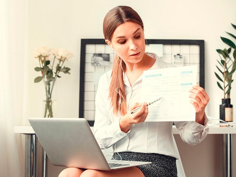 Mujer sentada señalando datos en una papeleta