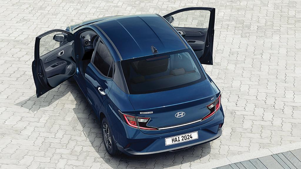 Vista aérea de Hyundai Grand i10 Sedán color azul con puertas delanteras abiertas