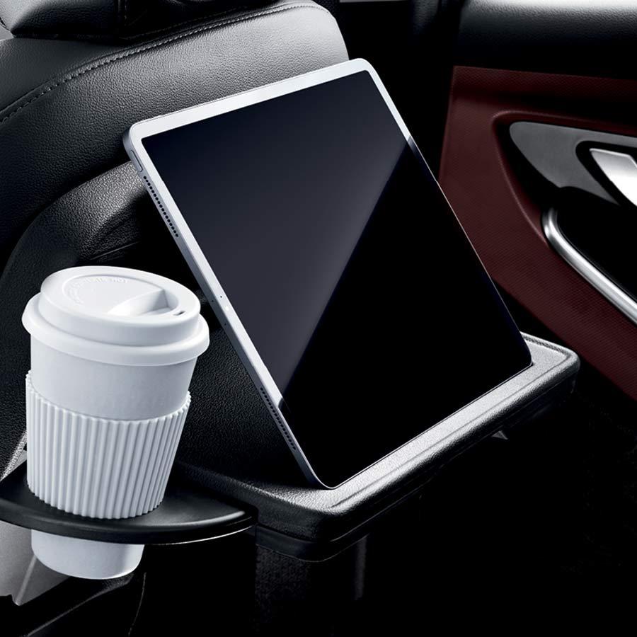 Mesa con posavasos en una Hyundai Creta Grand sosteniendo un vaso y una tableta