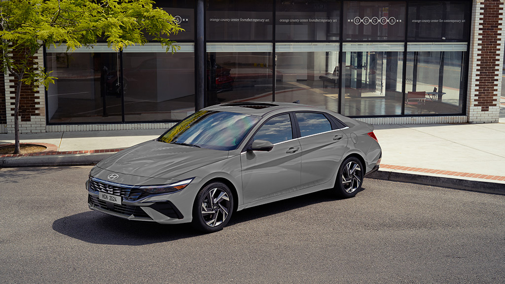 nuevo elantra 2024 vista 3/4 en gris, estacionado afuera de un edificio