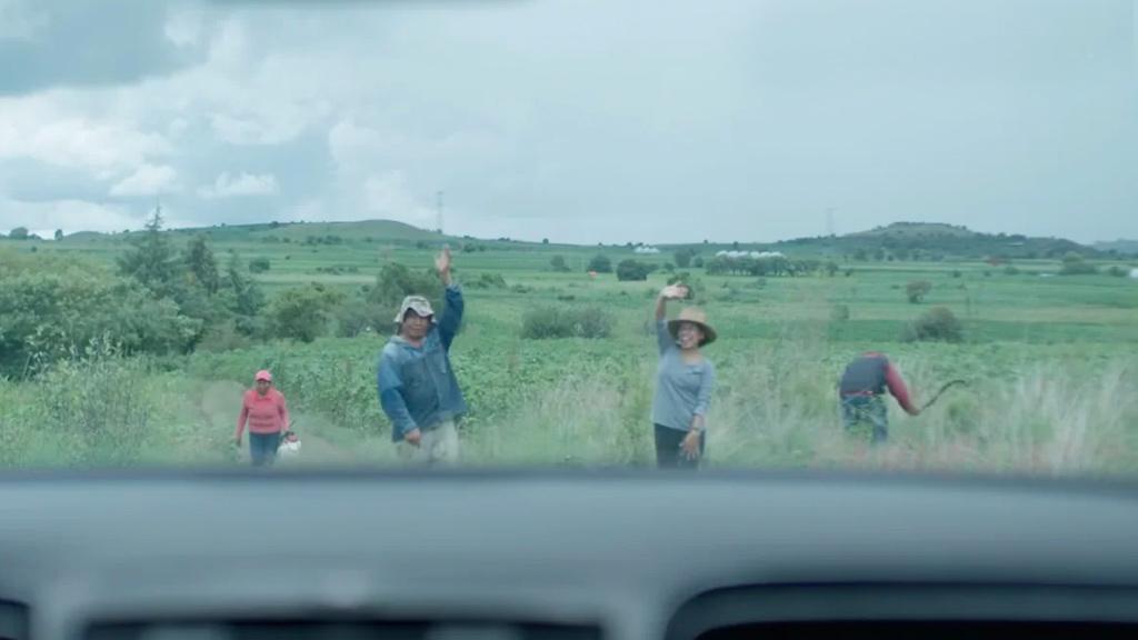 Campesinos saludando a conductor de vehículo