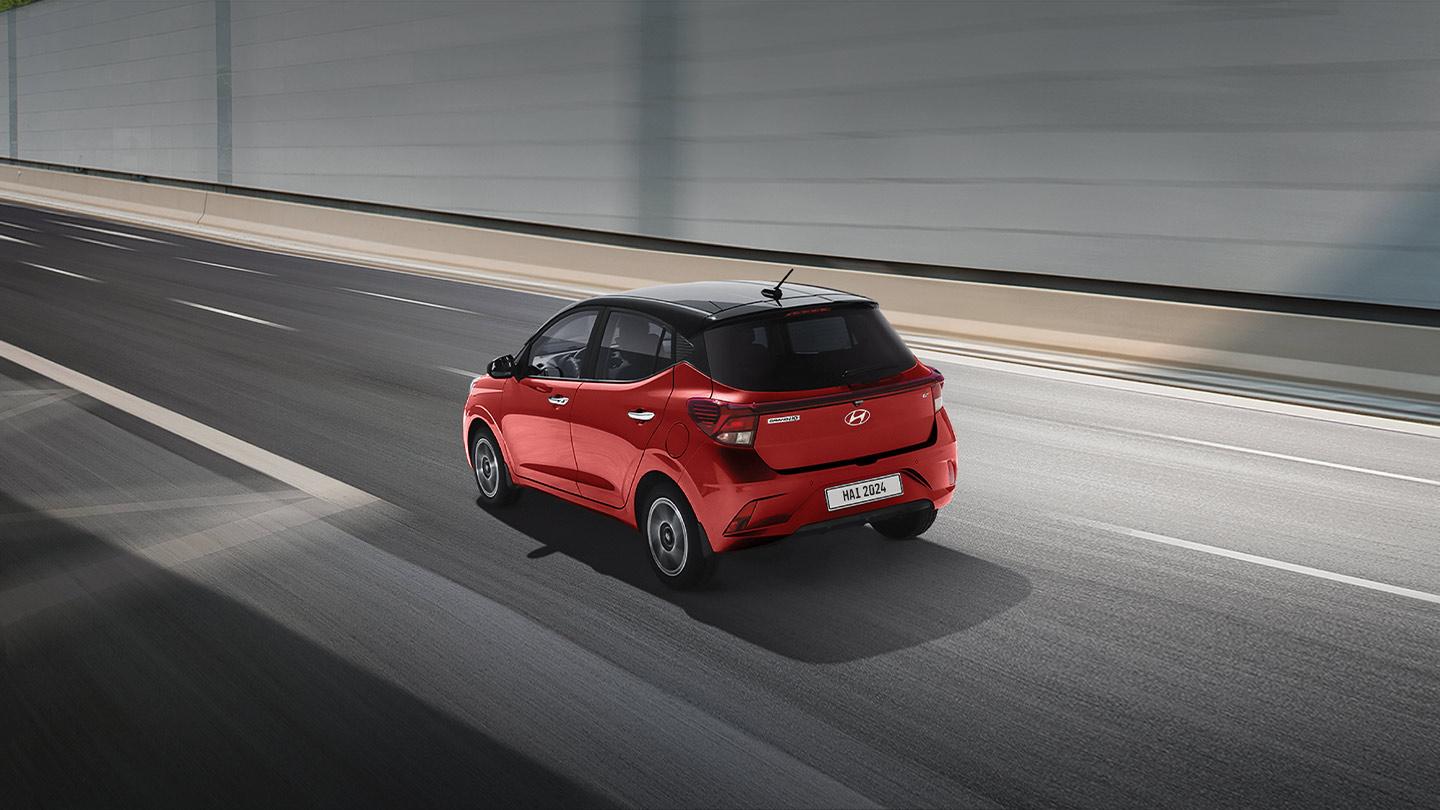 Hyundai Grand i10 Hatchback color rojo circulando en una pendiente