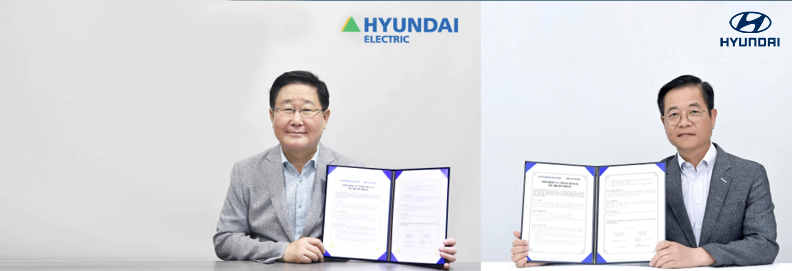 Ejecutivos de Hyundai Motor y Hyundai Electric mostrando carpetas con acuerdo